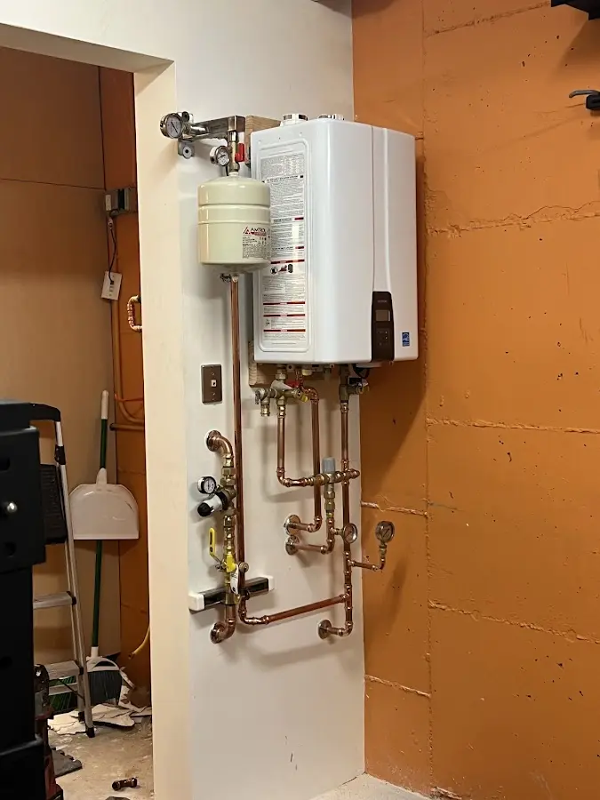 Plumbing technician inspecting water heater connections in Oak View